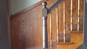 A wooden staircase with a handrail and a wooden banister. - Charming Tree Top Victorian - Two Bedroom Retreat (Boston)