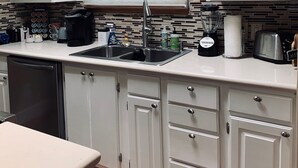 A compact kitchen with white cabinets, a double sink, and a window above the countertop. - Beautiful view,18 acres,pool, game room,Axis deer, 3 mile’s to the  river trail! (Kerrville)