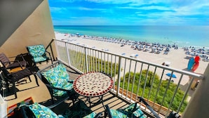 A balcony with a view of a beach and ocean.