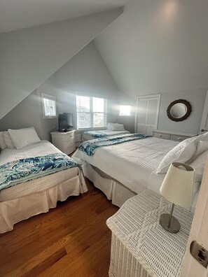 A bedroom with two beds, a dresser, a lamp, and a window. - Surfside! Fantastic Beach House, Near Restaurants, Cliff Walk, Close to Downtown (Middletown)