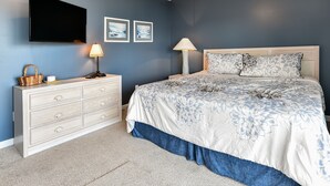 A bedroom with a bed, dresser, and two wall-mounted lamps. - Large Beach View House in Surfside, South Carolina (Surfside Beach)