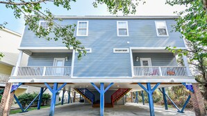 A two-story building with a blue exterior and a covered parking area. - Large Beach View House in Surfside, South Carolina (Surfside Beach)