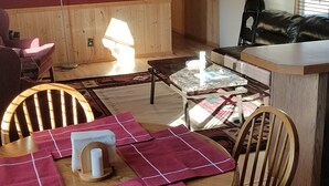 Een eethoek met een houten tafel, stoelen en een plafondventilator.