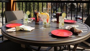 A round table with red plates, glasses with drinks, and a scenic mountain view in the background. - Ski in, Ski out, luxury resort. Exceptional snow (Truckee)