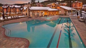 A resort with a large swimming pool, lounge chairs, and a snowy mountain backdrop. - Ski in, Ski out, luxury resort. Exceptional snow (Truckee)