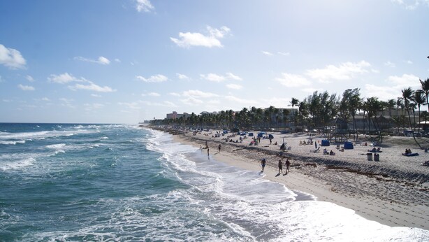 A beach with waves, people, and palm trees. - Stunning Indoor & Outdoor Living near Beach and Shopping. Close to Boca Raton (Deerfield Beach)