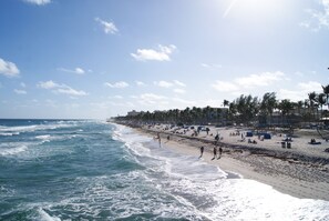 A beach with waves, people, and palm trees. - Stunning Indoor & Outdoor Living near Beach and Shopping. Close to Boca Raton (Deerfield Beach)