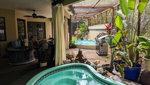 A pool area with a hot tub, surrounded by potted plants and a barbecue grill. - Stunning Indoor & Outdoor Living near Beach and Shopping. Close to Boca Raton (Deerfield Beach)