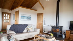 Una sala de estar acogedora con chimenea, un sofá, una mesa de centro y un televisor.
