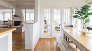 Ein geräumiger Wohnbereich mit Holzboden, weißen Wänden und einem großen Fenster.