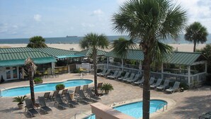 A resort with two swimming pools, lounge chairs, and a beach view. - Beachfront Luxury 1 BR Condo - 3 Oceanfront Pools (Tybee Island)