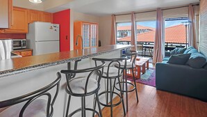 La cuisine est équipée d’un réfrigérateur, d’un four à micro-ondes et de tabourets de bar. On y trouve également un coin repas avec une table et des chaises, ainsi qu’un canapé dans le salon.
