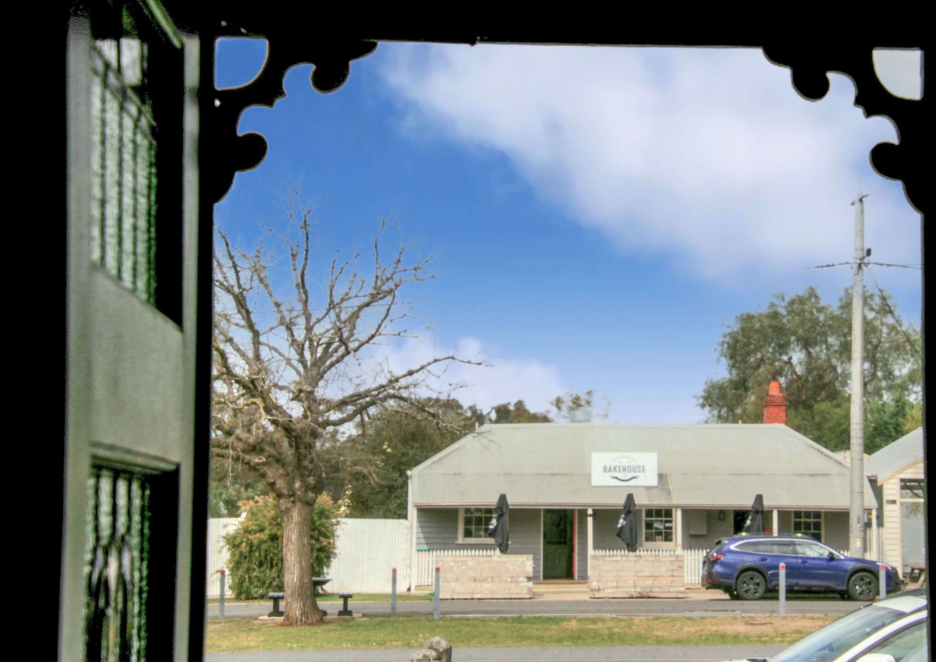 A building with a sign reading "Bakeryhouse" and a blue car parked in front.