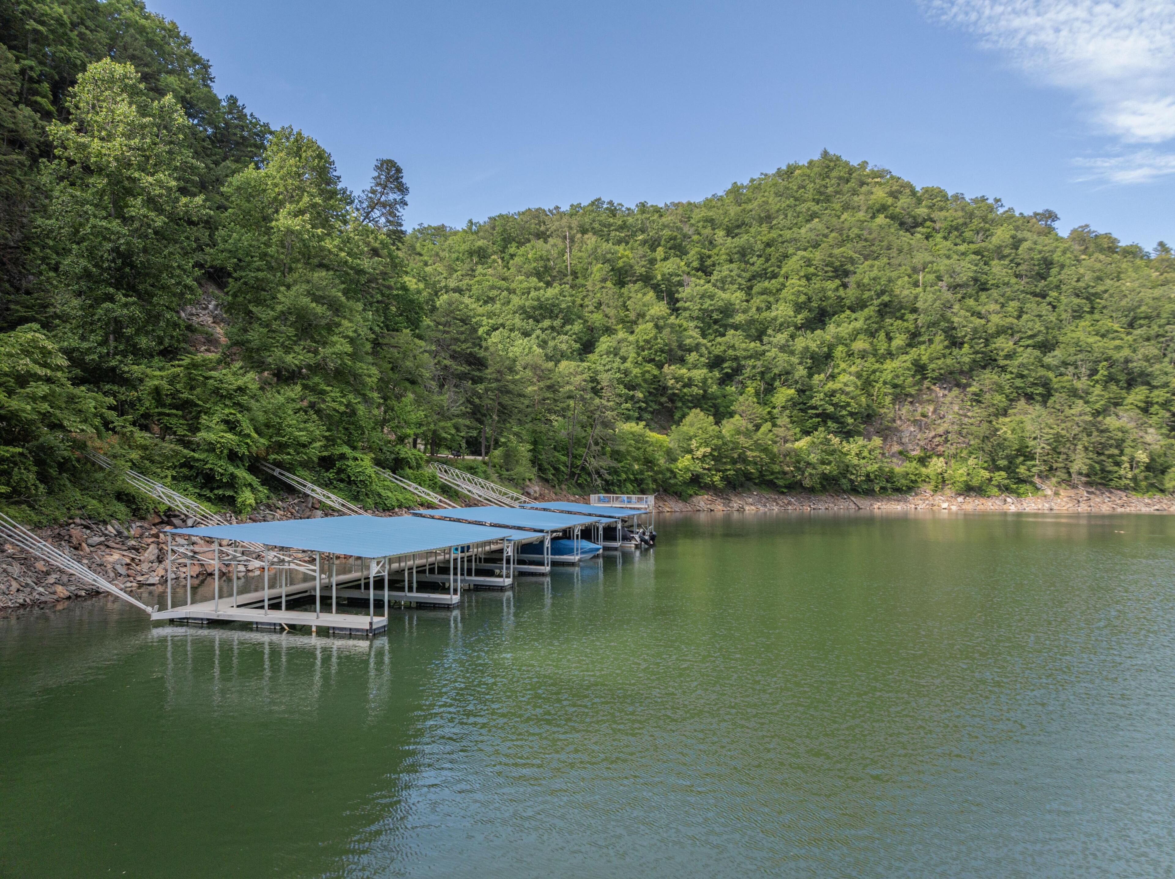 A calm lake with dock structures and a forested hillside.