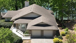 A two-story house with a steeply pitched roof, a covered front porch, and a garage. - Wonderful home with dock on Tellico Lake (Loudon)