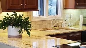 A kitchen with a granite countertop, wooden cabinets, a window with a view, and a potted plant. - Wonderful home with dock on Tellico Lake (Loudon)