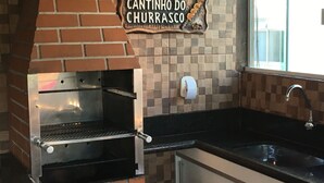 Un horno de ladrillo con un letrero encima que dice "Cantinho do Churrasco".
