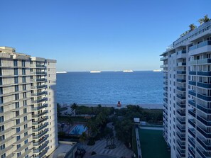 A high-rise hotel with balconies overlooking a body of water and several cruise ships in the distance. - Incredible Ocean Views! 2 BR/2.5 Bath, On Top of 1 Hotel! 15th Flr, 4 Pools! (Miami Beach)