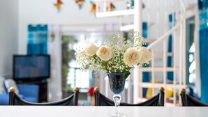 A dining table with a vase of white flowers.