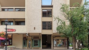 Ein mehrgeschossiges Gebäude mit einer zentralen Treppe, einem gut sichtbaren Eingang und einem Geschäft im Erdgeschoss.