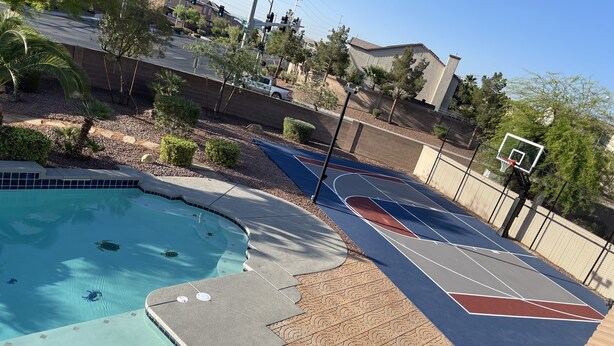 Una piscina con una cancha de baloncesto y un aro de baloncesto.