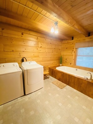 L’intérieur d’une cabane en bois comprend une machine à laver, un sèche-linge et une baignoire.