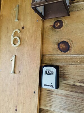 Une porte en bois portant le numéro « 161 » et équipée d’un cadenas de la marque Master Lock.