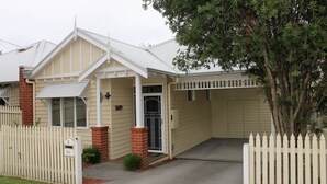Ein zweistöckiges Haus mit Satteldach, einer Veranda und einer Garage.