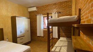 Een kamer met een stapelbed, een kledingkast en een raam met gordijnen.
