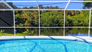 A swimming pool with clear blue water, surrounded by a white fence and lush greenery. - Relax in our PRIVATE Pool at Water View Villa (Venice)