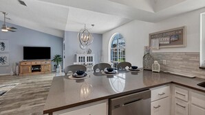 A modern kitchen with a central island, built-in dishwasher, and a large window providing natural light. - Relax in our PRIVATE Pool at Water View Villa (Venice)