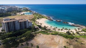 A coastal hotel with multiple buildings, a beach, and a view of the ocean.
