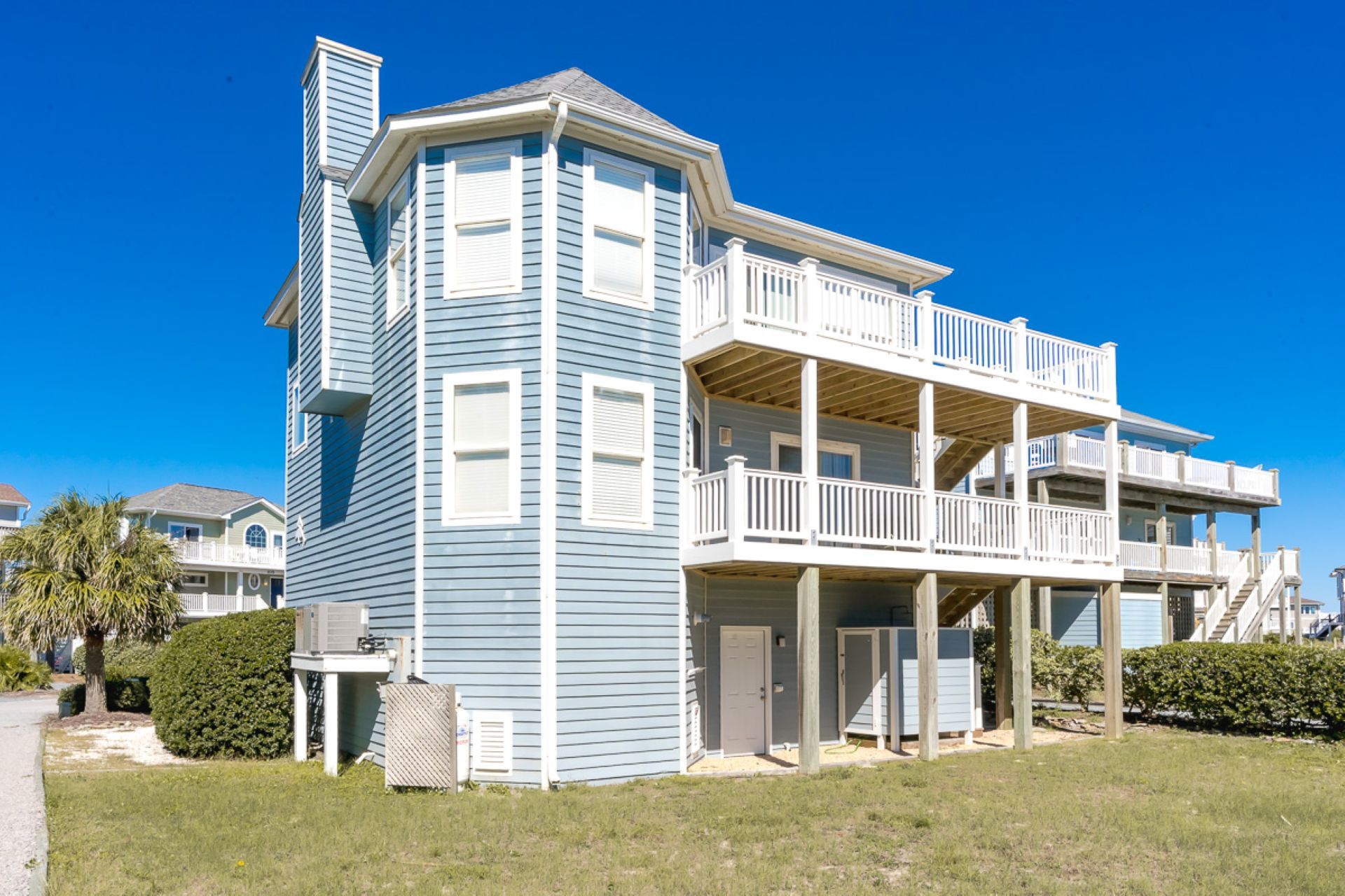 A two-story building with a balcony on the upper level and a covered porch on the ground level.