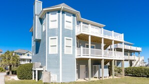 A two-story building with a balcony on the upper level and a covered porch on the ground level. - Boca North - Ocean View 3BR Home & Community Pool!!! (North Topsail Beach)