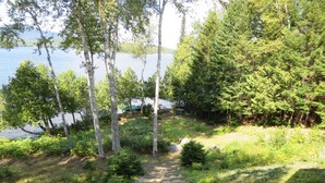 A stone pathway leading to a lake surrounded by trees. - SUNDOWN ON MOOSEHEAD LAKE - PLEASE READ THE ENTIRE DESCRIPTION  BEFORE BOOKING. (Greenville)