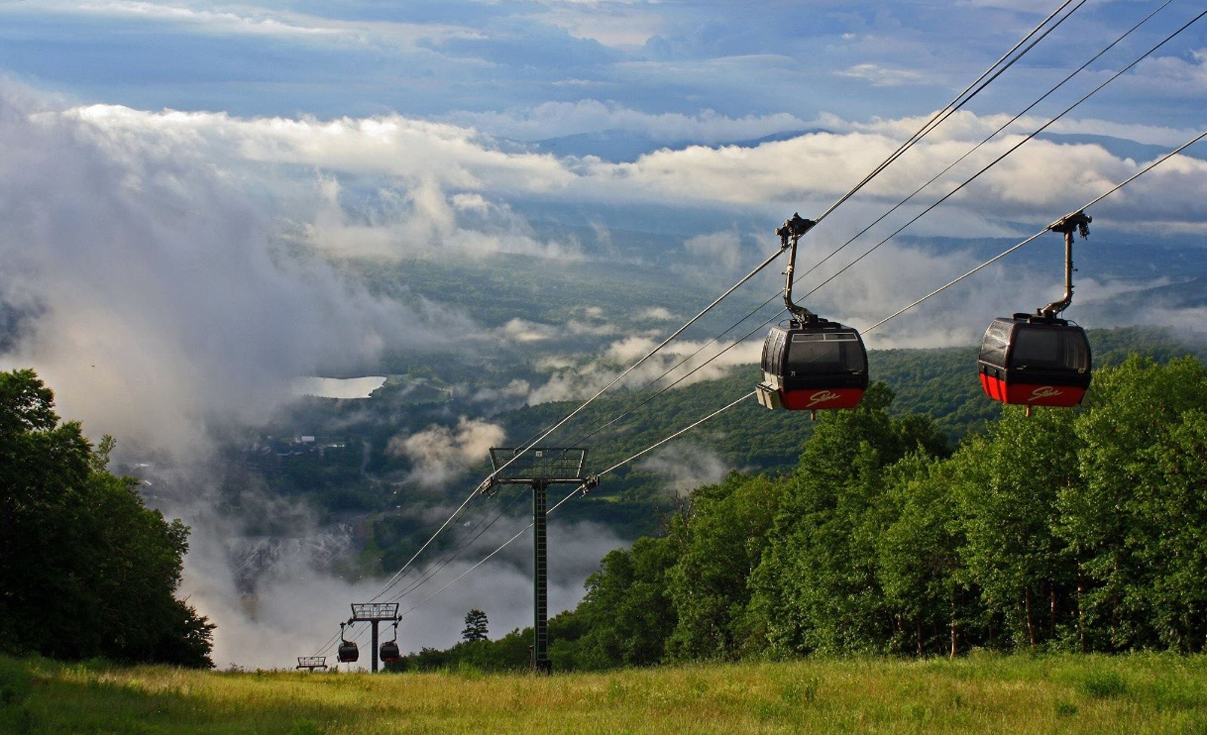 Un sistema de teleférico con un paisaje montañoso de fondo.