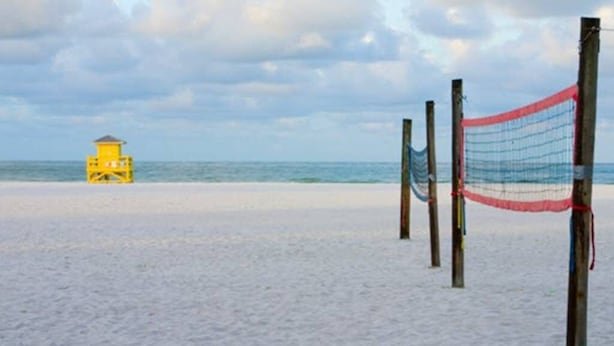 A beach with a lifeguard tower and a volleyball net. - Private guesthouse near the beach (Sarasota)
