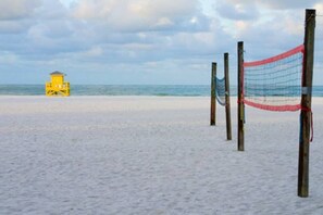 Une plage avec une tour de surveillance pour les sauveteurs et un filet de volley-ball.