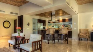 Un espacio habitable amplio con techo alto, una cocina equipada con electrodomésticos modernos y un mobiliario cómodo.