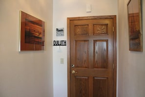 A wooden door with a sign above it stating "Manitoba The Land of 10,000 Lakes" and "DULUTH" on the wall to the left.