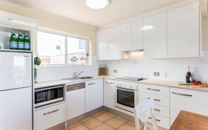 Fully equipped kitchen with refrigerator, microwave, dishwasher, and sink.