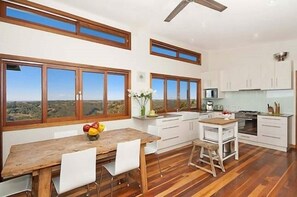 Enjoy meals in the kitchen with a central island, dining area, and large windows offering a view of the surrounding landscape.