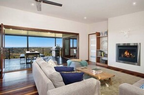 Relax by the fireplace in this inviting living space, featuring a comfortable seating area and a large window with a view.