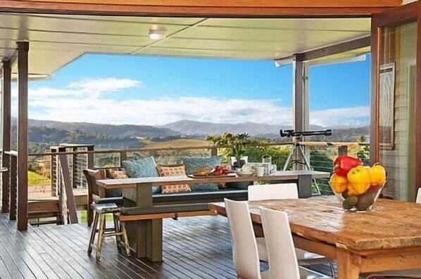 Enjoy al fresco dining or relaxation on the deck, surrounded by the serene landscape of hills and greenery.