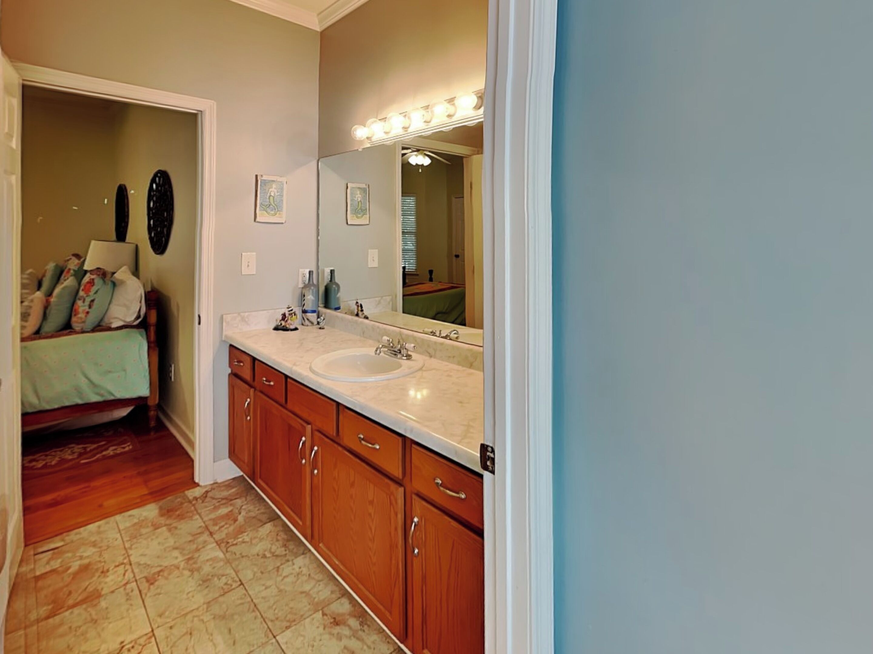A bathroom with a vanity, sink, and mirror.