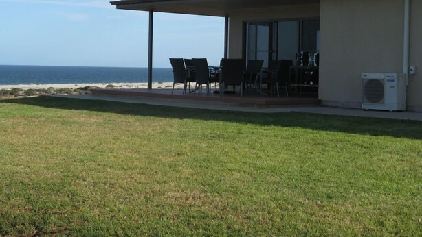 Un edificio con un patio techado con vista a la playa.