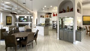 Una cocina amplia con una isla, electrodomésticos modernos y un comedor con una mesa grande y sillas.