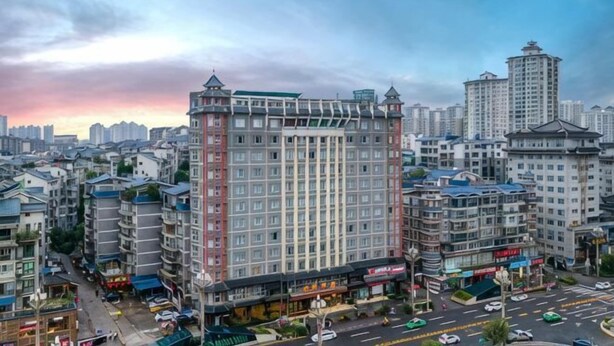 A high-rise hotel with multiple floors, a central courtyard, and surrounding commercial buildings. - Jinguan Hotel (Kaili)