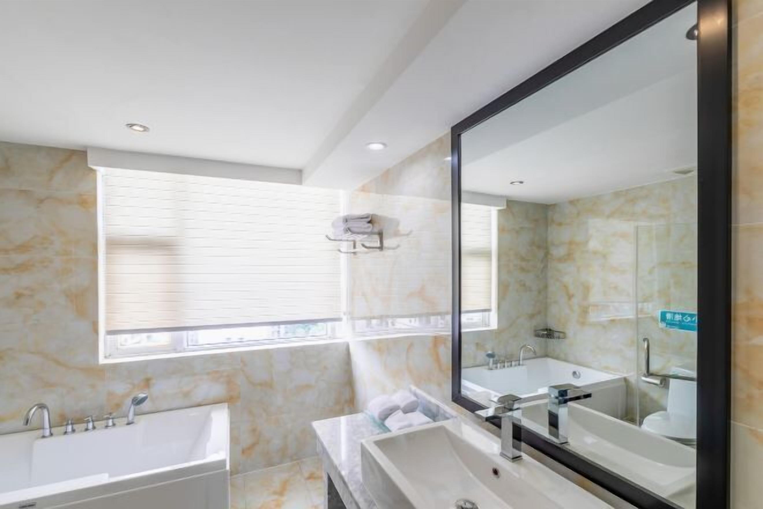 Casa de banho moderna com um espelho grande, duas pias e uma janela.