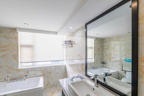 Casa de banho moderna com um espelho grande, duas pias e uma janela.